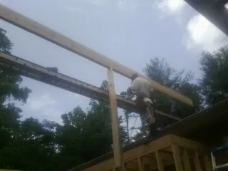 Carpenter setting a ridge beam over a new addition frame — Ice Dam Removal by Roofing Brothers in Shelbyville