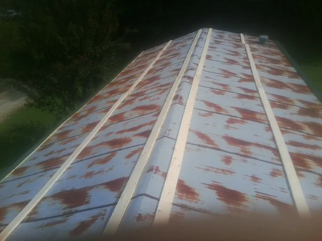 Rusted metal roof panels with new wood purlins before replacement — Storm Damage Roof Repair in Shelbyville by Roofing Brothers