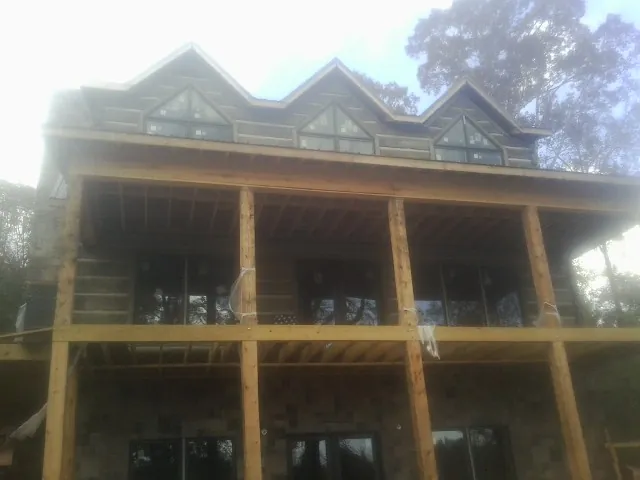 Dormers and porch framing on a large log home under construction — Roof Coating work by our crew in Shelbyville
